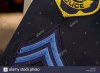 close-up-of-police-patch-and-corporal-stripes-on-a-blue-uniform-shirt-E4CW5N.jpg